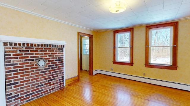 unfurnished room with light wood-type flooring, baseboard heating, and crown molding