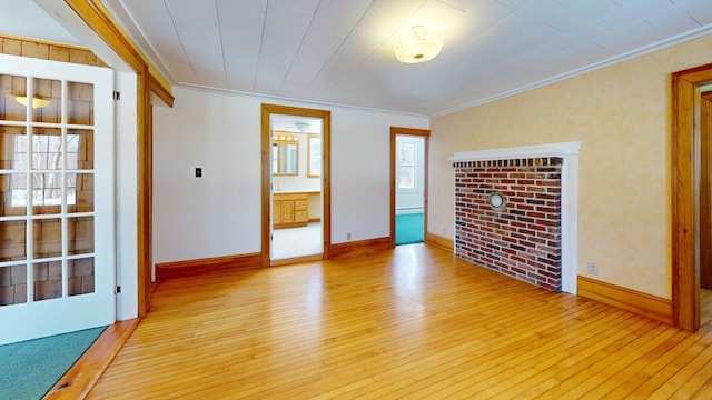 empty room with light wood-type flooring, baseboards, and ornamental molding