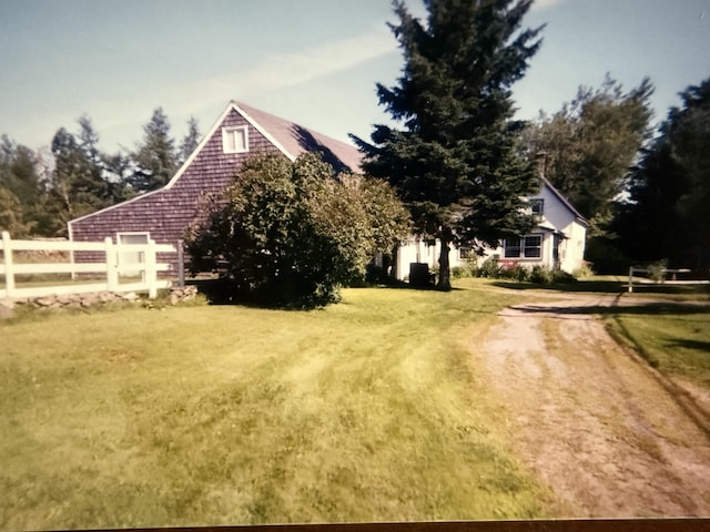 view of yard with driveway and fence