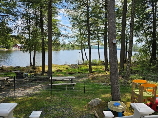 view of yard with a water view and fence