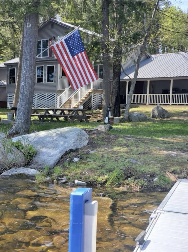 view of home's exterior with stairway and a water view