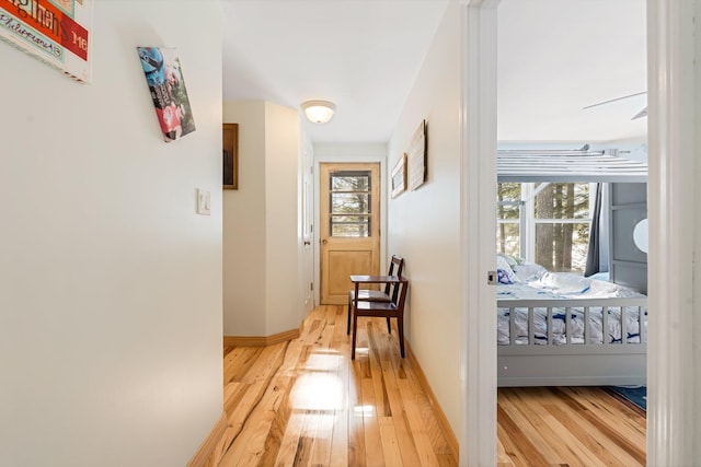 corridor with baseboards and wood finished floors