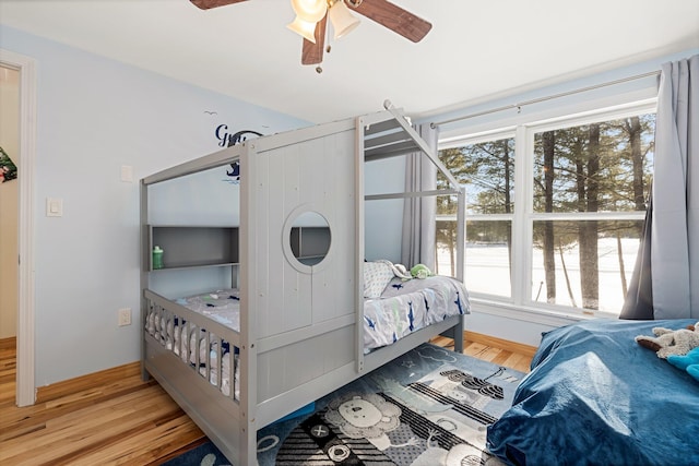 bedroom featuring a ceiling fan, baseboards, and wood finished floors