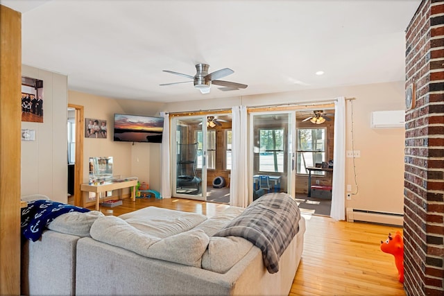 living area featuring a baseboard radiator, light wood-style flooring, and a wall mounted AC