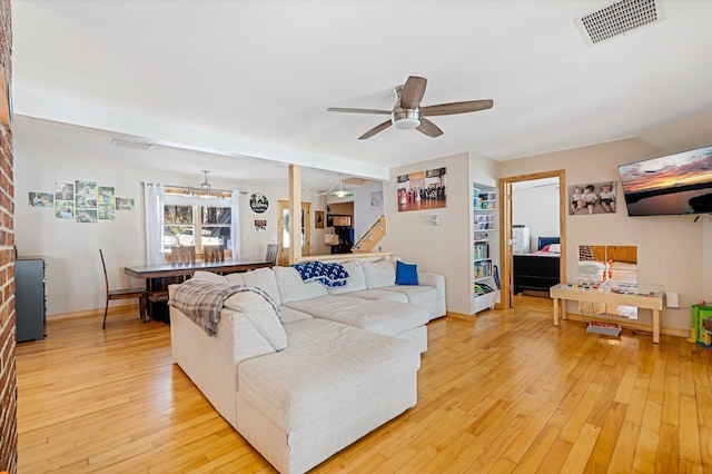 living area with ceiling fan, wood finished floors, visible vents, and baseboards