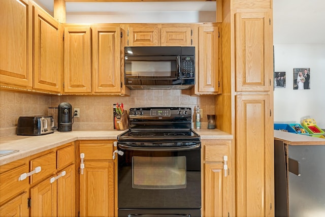 kitchen featuring black appliances, light countertops, and backsplash