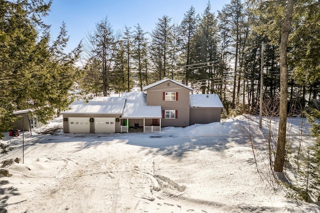 view of front facade featuring an attached garage, covered porch, and driveway