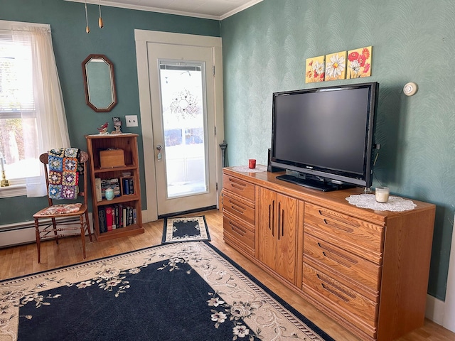 interior space with crown molding, a baseboard heating unit, and light wood-type flooring