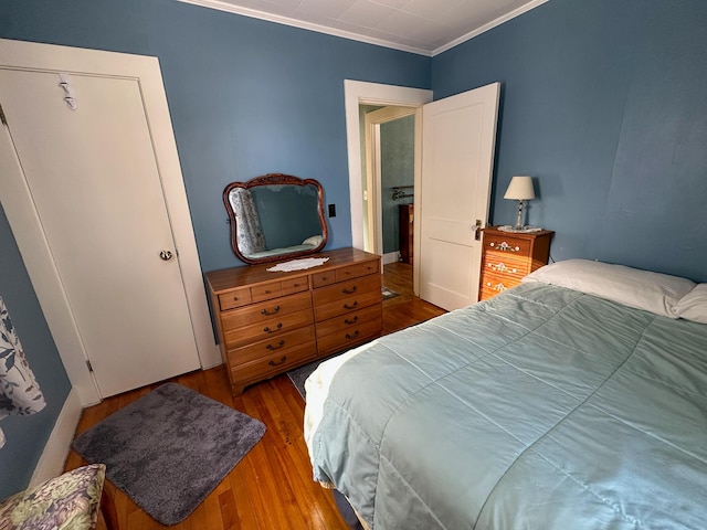 bedroom with hardwood / wood-style flooring and ornamental molding