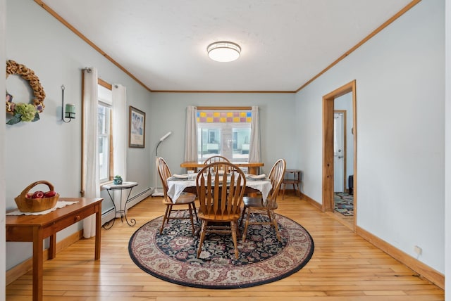 dining space featuring crown molding, a baseboard heating unit, and light wood-type flooring