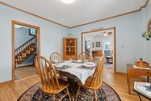 dining space with light hardwood / wood-style flooring, a baseboard radiator, and ornamental molding