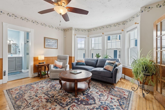 living room with wooden walls, hardwood / wood-style floors, and a textured ceiling