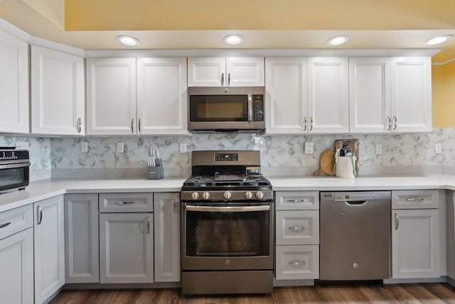 kitchen with white cabinetry, backsplash, stainless steel appliances, and gray cabinetry