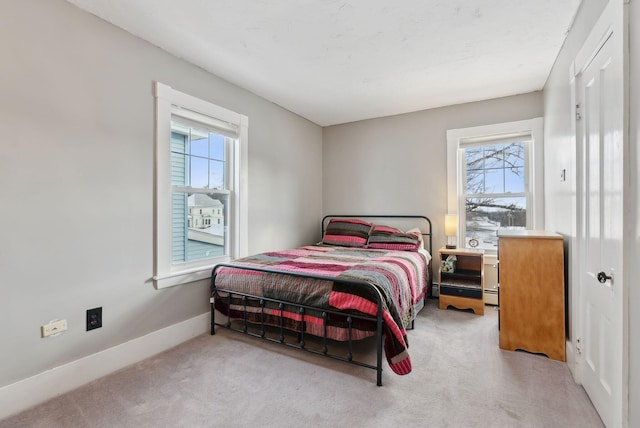 carpeted bedroom featuring multiple windows and baseboard heating