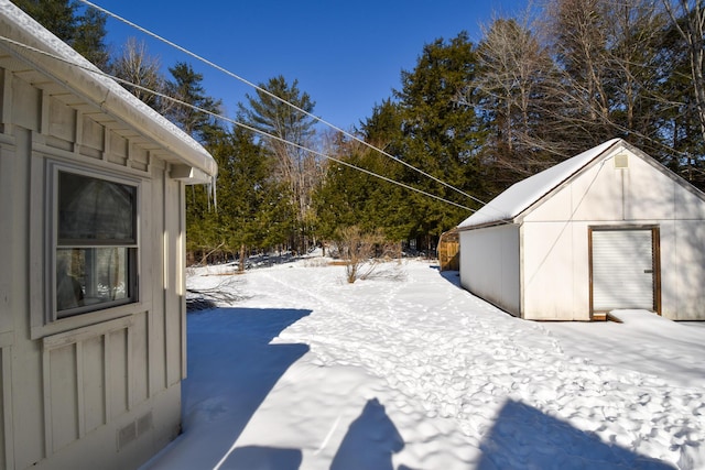 snowy yard featuring an outdoor structure