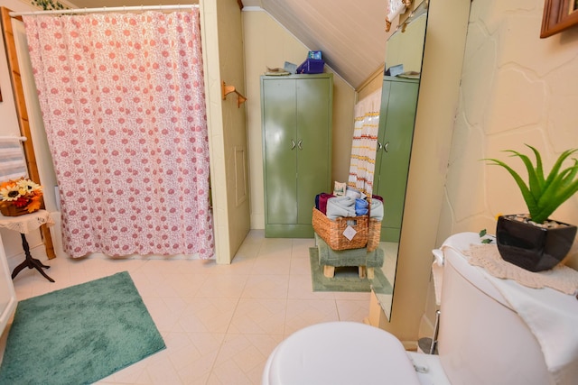 bathroom featuring lofted ceiling, toilet, and a shower with shower curtain