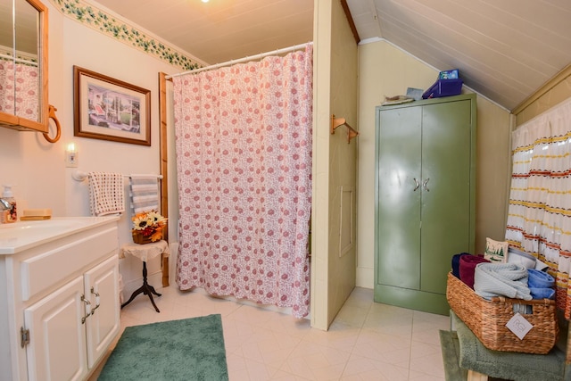 bathroom featuring vanity, curtained shower, and vaulted ceiling