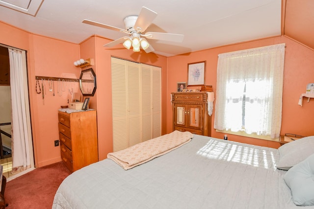 bedroom with vaulted ceiling, a closet, ceiling fan, and carpet flooring