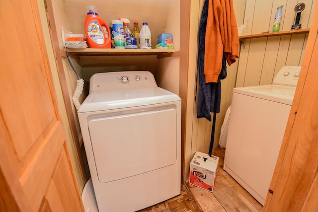 washroom featuring washer and dryer and wood walls