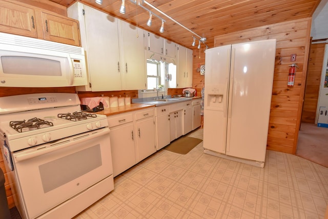 kitchen featuring sink, wood ceiling, track lighting, wooden walls, and white appliances