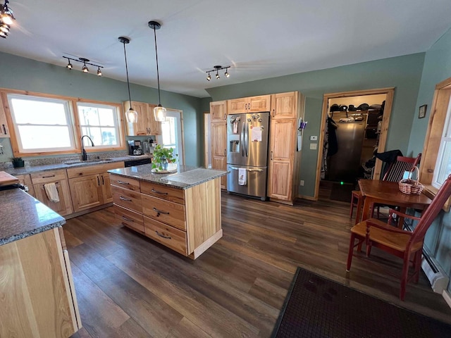 kitchen with decorative light fixtures, sink, stainless steel fridge, dark hardwood / wood-style flooring, and a center island