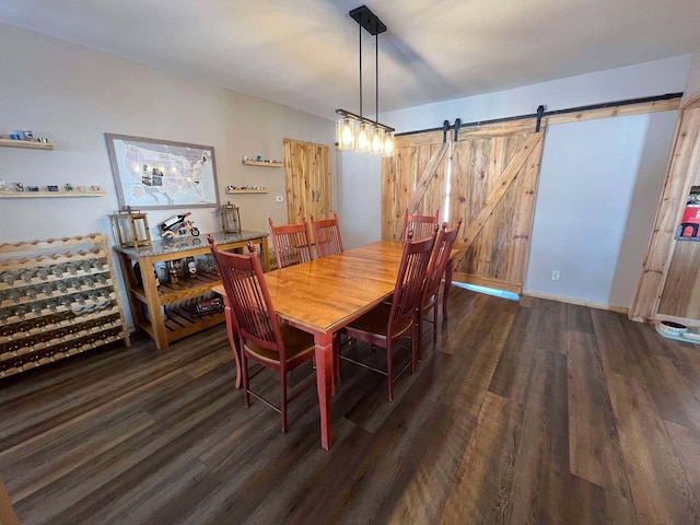 dining space featuring a barn door and dark hardwood / wood-style flooring