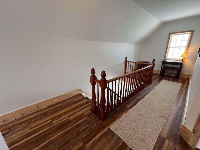 stairway with lofted ceiling and hardwood / wood-style floors