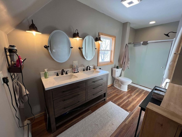 bathroom featuring hardwood / wood-style flooring, a shower, vanity, and toilet