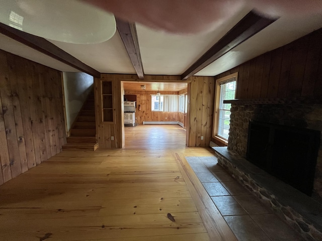 83 River Rd, Hiram, ME 04041 - unfurnished living room with wooden walls, beam ceiling, hardwood / wood-style floors, stairway, and baseboard heating