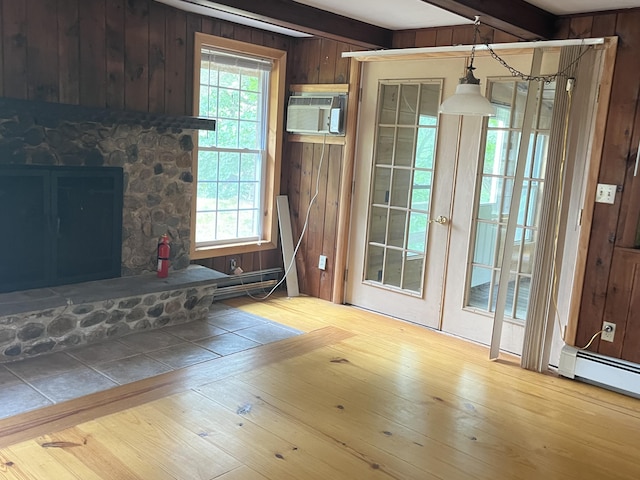 83 River Rd, Hiram, ME 04041 - unfurnished living room featuring wooden walls, an AC wall unit, beamed ceiling, hardwood / wood-style flooring, and a fireplace