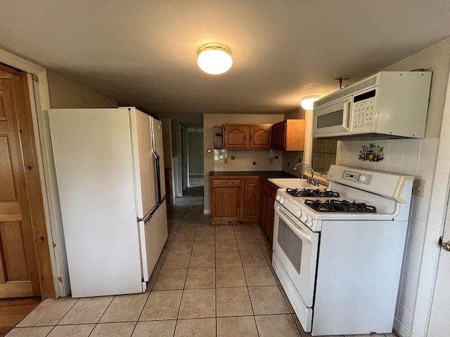 83 River Rd, Hiram, ME 04041 - kitchen with white appliances, light tile patterned flooring, and brown cabinetry