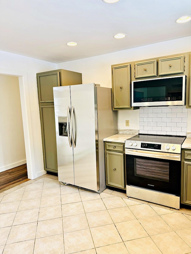 kitchen with recessed lighting, backsplash, appliances with stainless steel finishes, light countertops, and light tile patterned floors