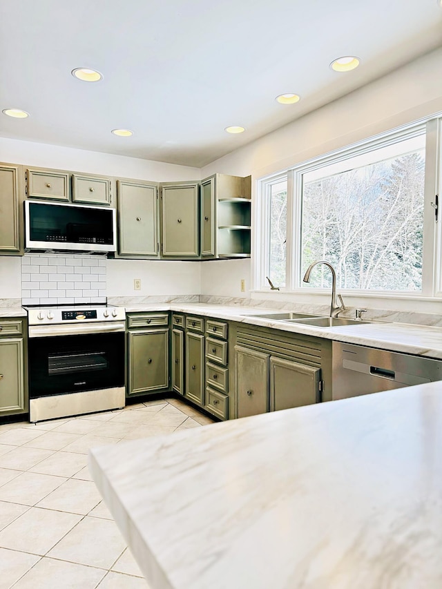 kitchen featuring open shelves, a sink, light tile patterned floors, stainless steel appliances, and recessed lighting