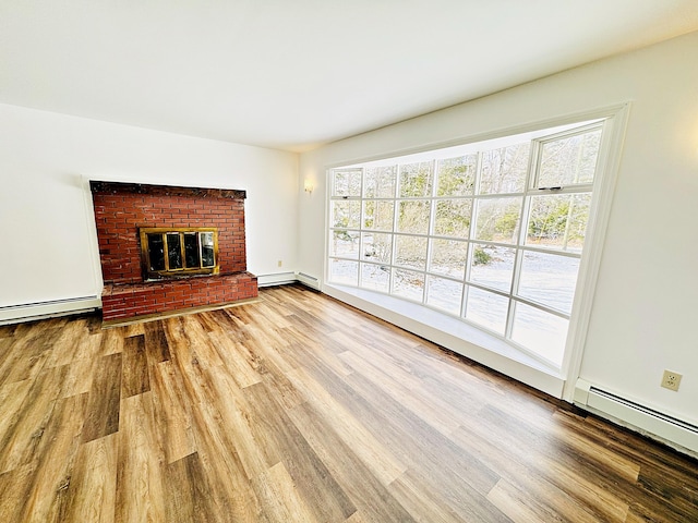 unfurnished living room with a baseboard heating unit, wood finished floors, a baseboard radiator, and a fireplace