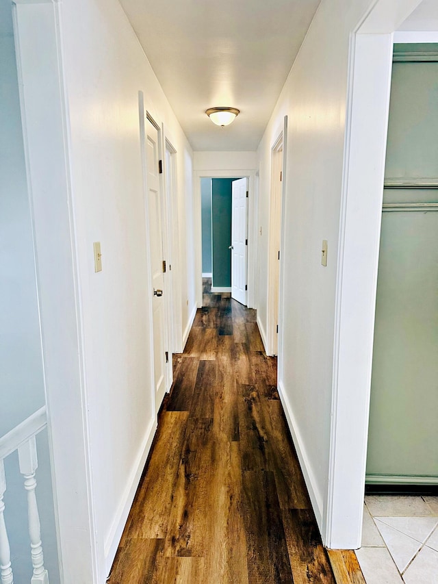 hallway featuring wood finished floors and baseboards