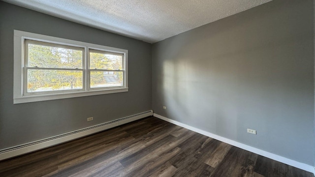 spare room featuring a baseboard heating unit, baseboards, a textured ceiling, and dark wood-style floors