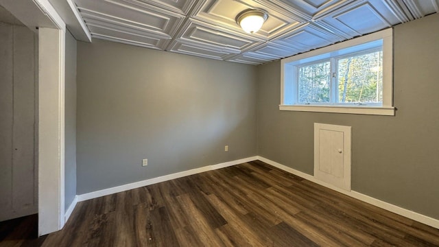 spare room featuring baseboards and dark wood-style flooring