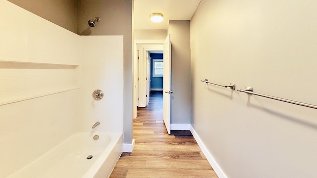 full bathroom with wood finished floors, baseboards, and bathtub / shower combination
