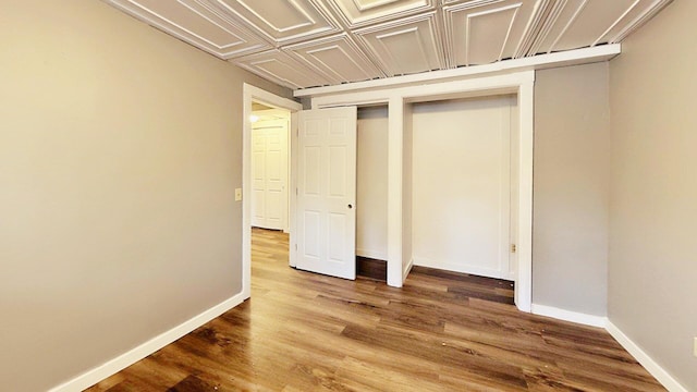 unfurnished bedroom with wood finished floors and baseboards