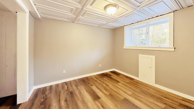 spare room with baseboards and wood finished floors