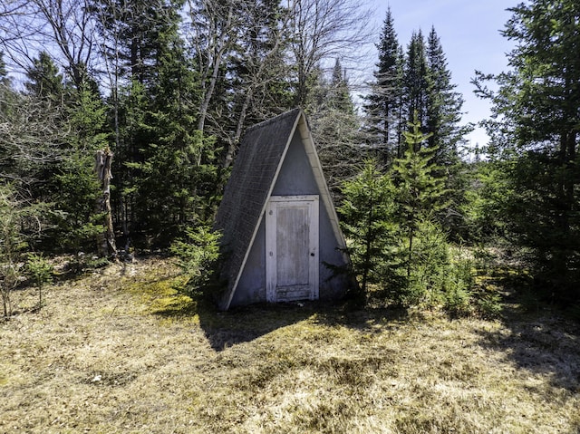 view of shed with a wooded view