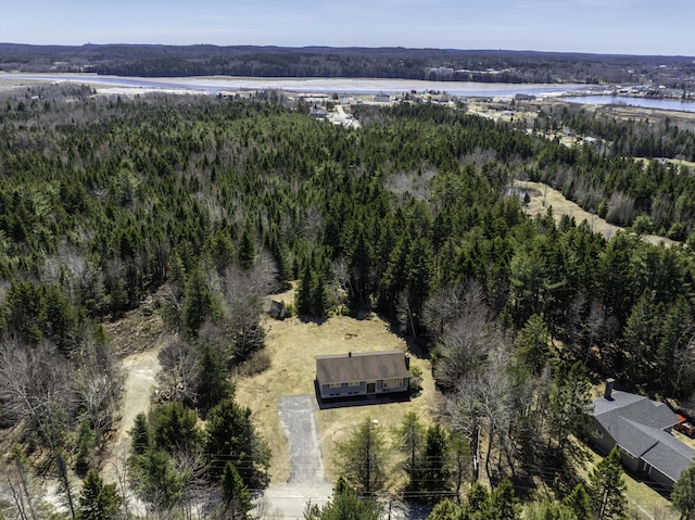 drone / aerial view with a forest view and a water view