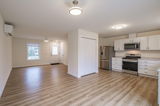26 Townsend Ln, Boothbay, ME 04537 - kitchen featuring light countertops, stainless steel appliances, light wood-style flooring, and a wall mounted air conditioner