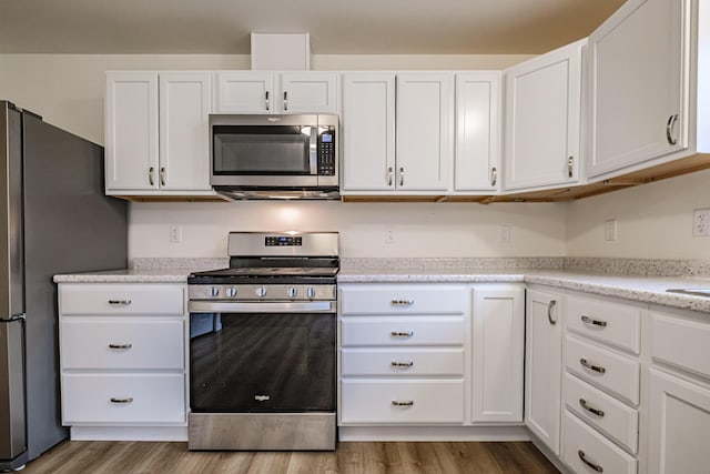 26 Townsend Ln, Boothbay, ME 04537 - kitchen with white cabinetry, appliances with stainless steel finishes, and wood finished floors