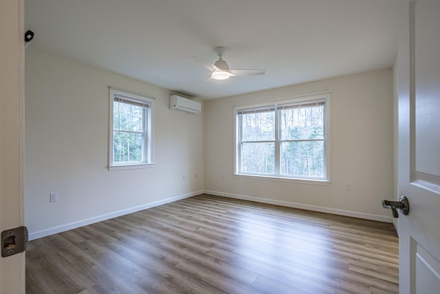 26 Townsend Ln, Boothbay, ME 04537 - unfurnished room with baseboards, a wall mounted air conditioner, a ceiling fan, and wood finished floors