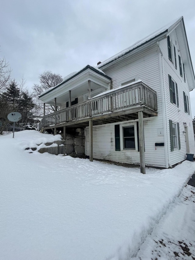 view of snow covered exterior with a deck