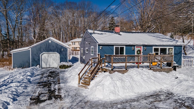 view of front of property featuring a garage, an outdoor structure, and a deck