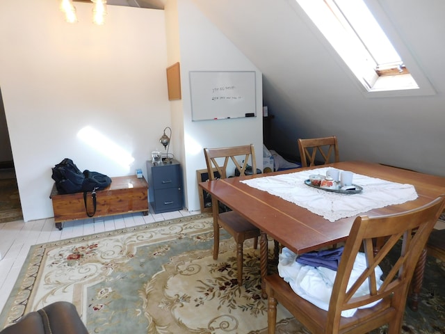 dining room featuring lofted ceiling with skylight