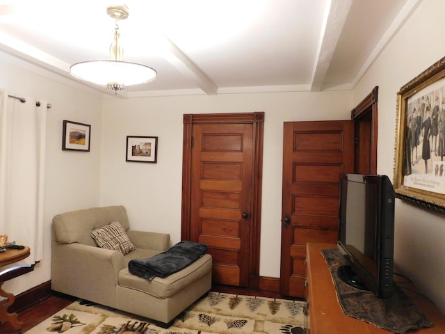 sitting room with dark wood-type flooring and beam ceiling