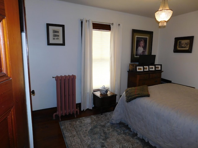 bedroom with dark wood-type flooring, radiator, and multiple windows